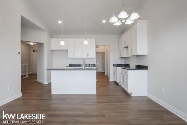 kitchen featuring white cabinetry, pendant lighting, an island with sink, and dark hardwood / wood-style flooring