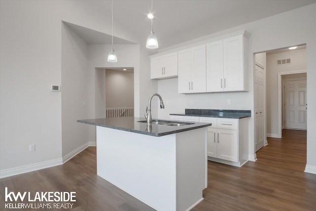 kitchen with white cabinetry, sink, pendant lighting, and a center island with sink