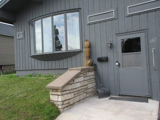 doorway to property with a lawn