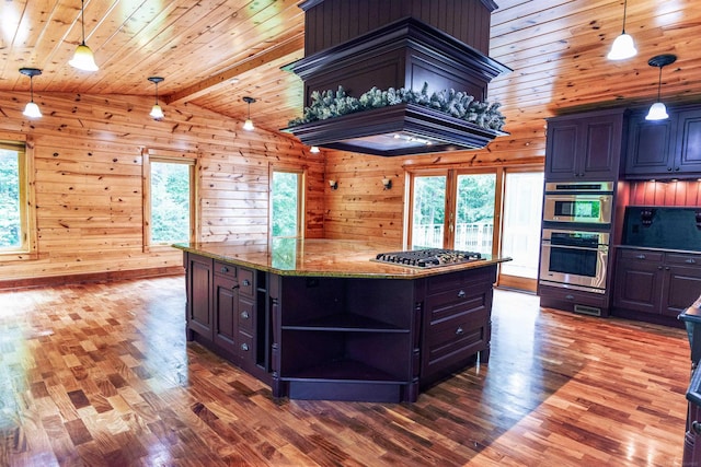 kitchen featuring a center island, lofted ceiling with beams, stainless steel appliances, hardwood / wood-style flooring, and wooden walls