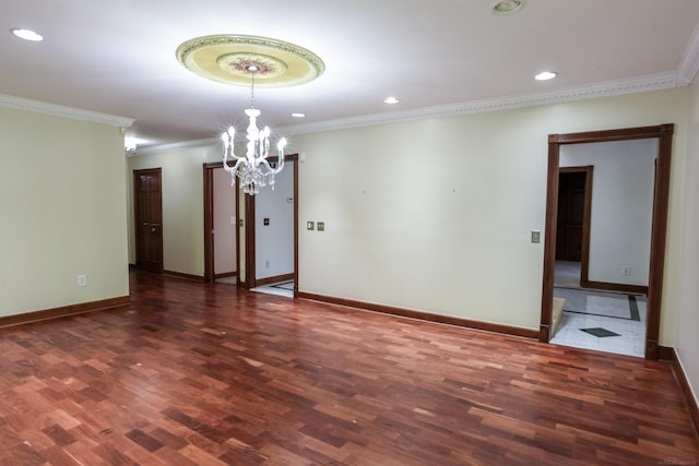 empty room with dark hardwood / wood-style flooring, a chandelier, and crown molding