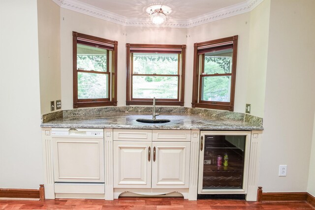 kitchen featuring beverage cooler, dishwasher, white cabinetry, light stone countertops, and sink