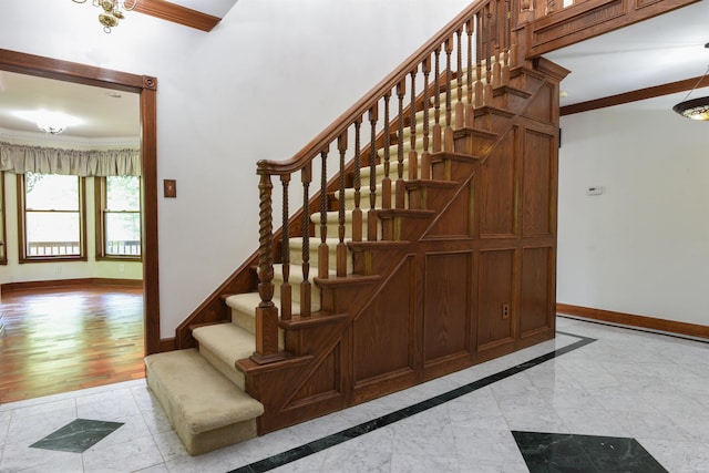 staircase with ornamental molding and light hardwood / wood-style flooring