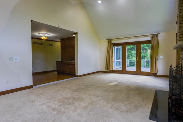 unfurnished living room with high vaulted ceiling, sink, and hardwood / wood-style floors