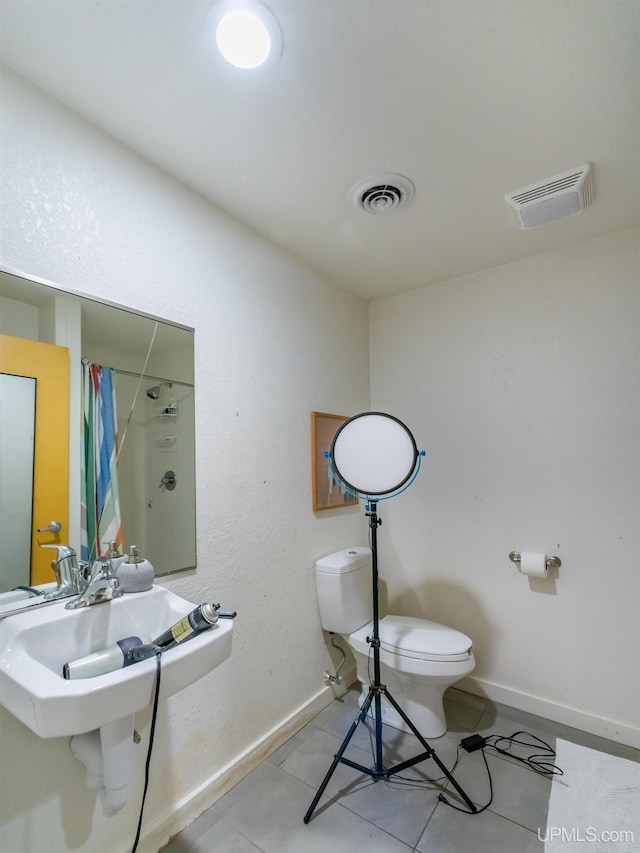 bathroom with tile patterned floors, a shower with curtain, sink, and toilet