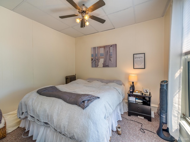 carpeted bedroom with radiator, a paneled ceiling, and ceiling fan