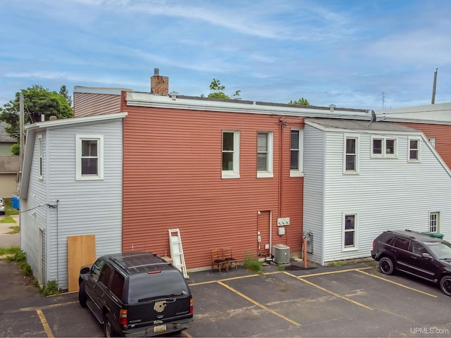 rear view of house featuring central AC