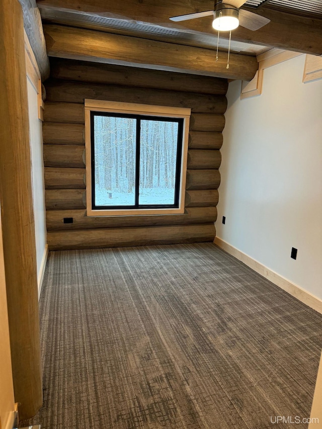 carpeted spare room with a ceiling fan, beamed ceiling, and baseboards