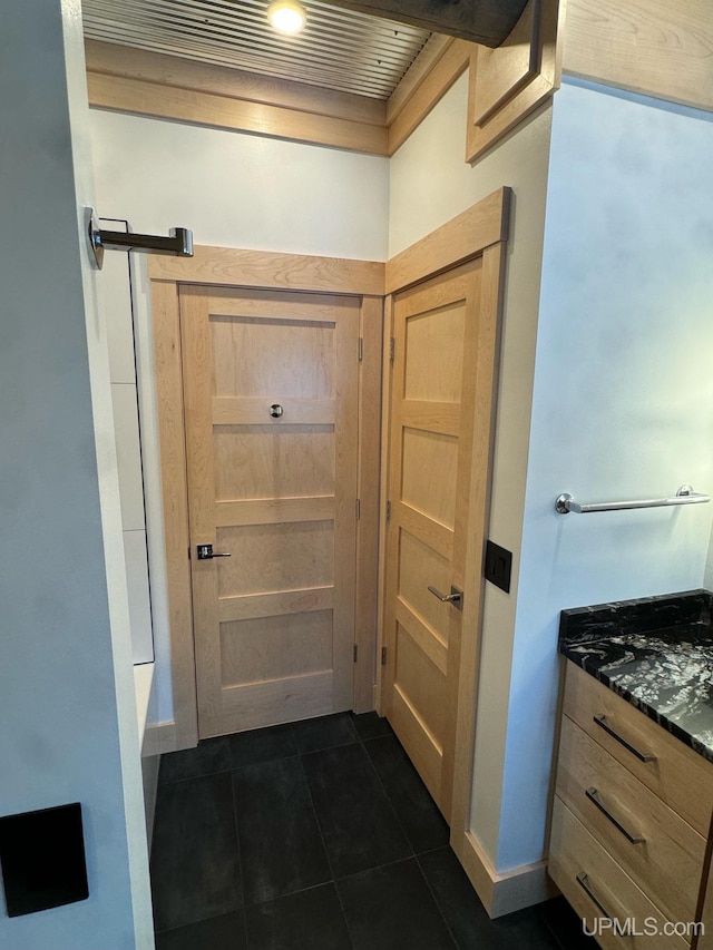 doorway featuring dark tile patterned flooring