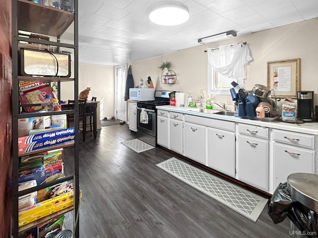 kitchen featuring white cabinets, dark hardwood / wood-style floors, sink, and stainless steel gas range oven