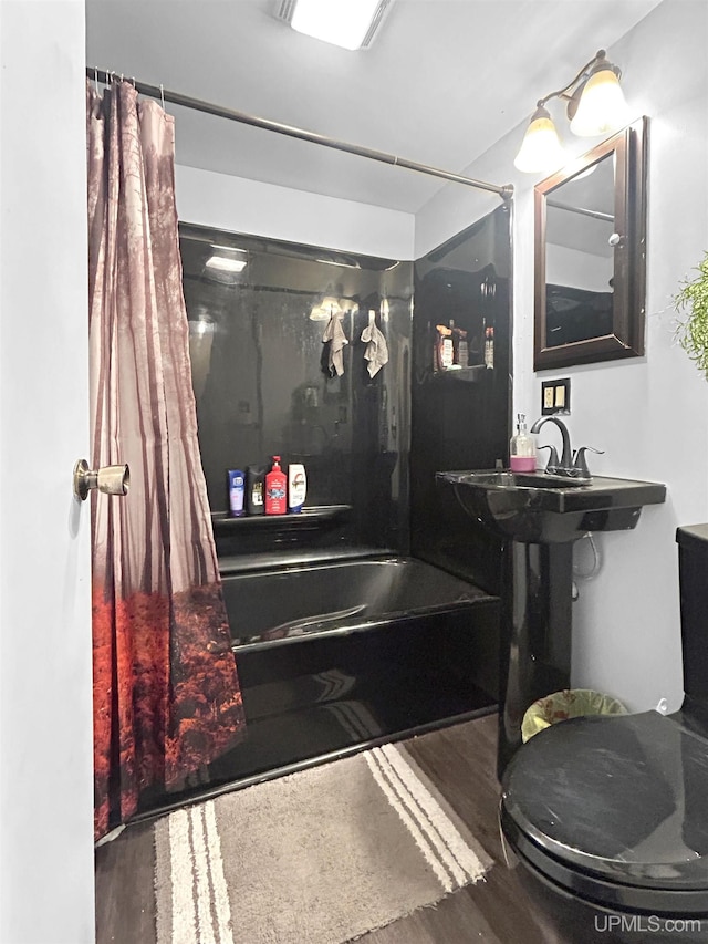 full bathroom featuring toilet, sink, hardwood / wood-style flooring, and shower / bath combo with shower curtain