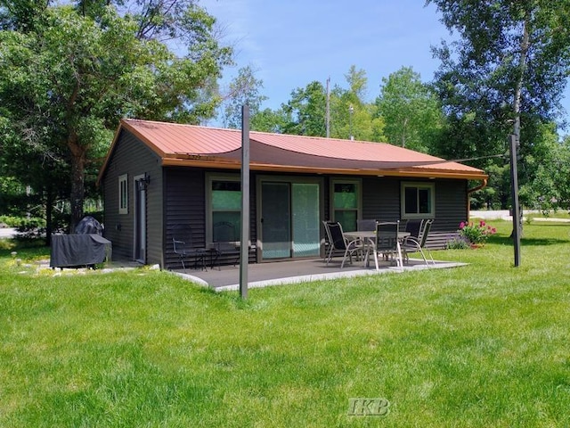 back of house with a lawn and a patio