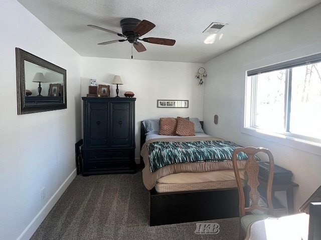 carpeted bedroom featuring ceiling fan and a textured ceiling