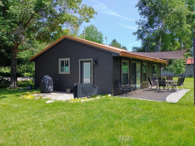 back of house with a yard and a patio