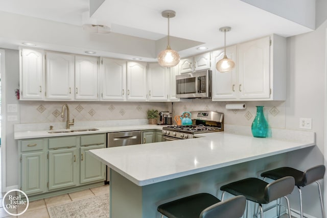 kitchen with backsplash, sink, white cabinetry, kitchen peninsula, and stainless steel appliances