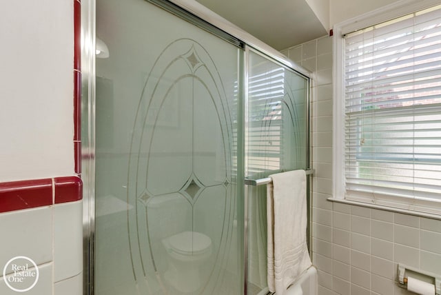 bathroom with toilet, tile walls, and walk in shower