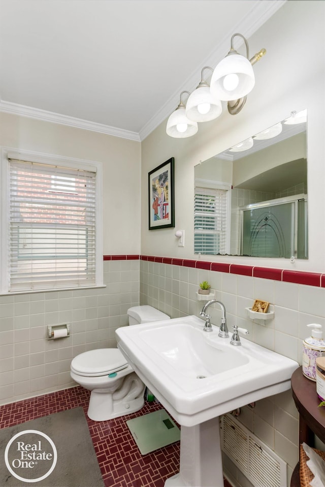 bathroom featuring tile patterned floors, an enclosed shower, crown molding, tile walls, and toilet