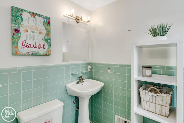 bathroom with sink, tile walls, and toilet