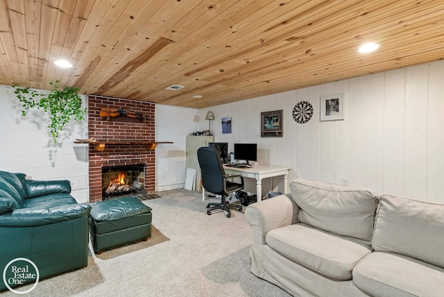 carpeted office space featuring wooden walls, wooden ceiling, and a brick fireplace