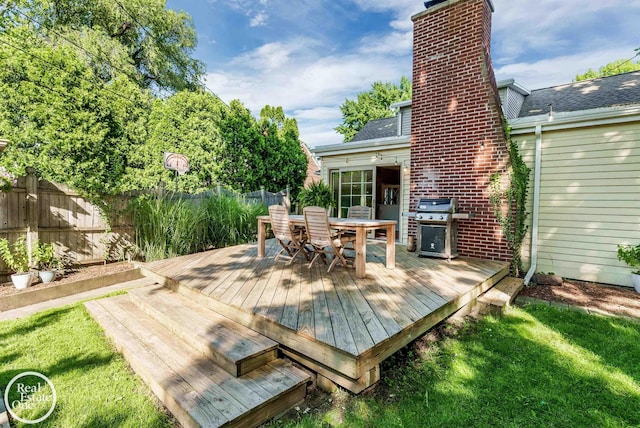 wooden terrace featuring a yard and area for grilling