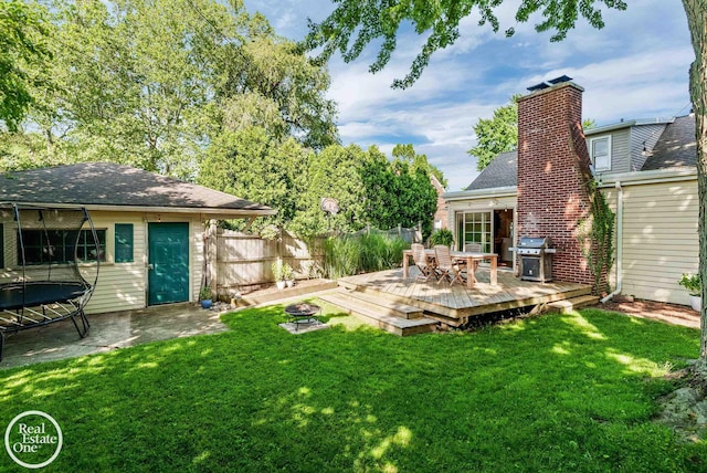 view of yard with a trampoline and a deck