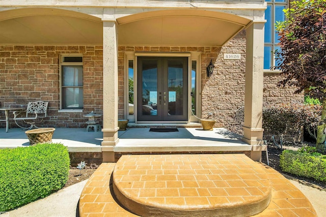 doorway to property with covered porch and french doors