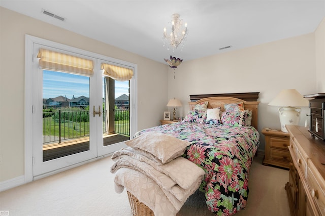 bedroom featuring light carpet, access to outside, and a notable chandelier