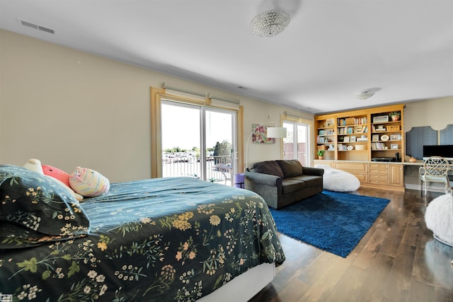 bedroom featuring access to exterior, hardwood / wood-style floors, and built in desk