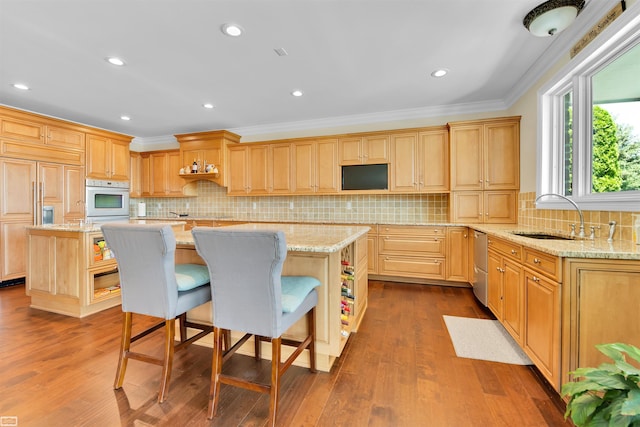 kitchen with hardwood / wood-style floors, a kitchen island, and sink