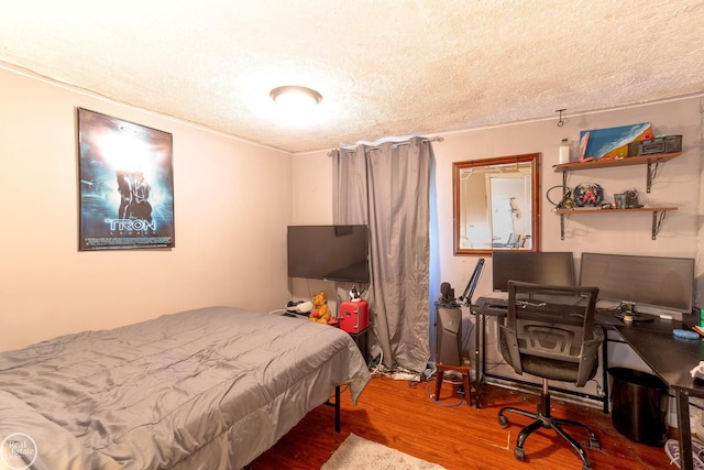 bedroom with hardwood / wood-style flooring and a textured ceiling