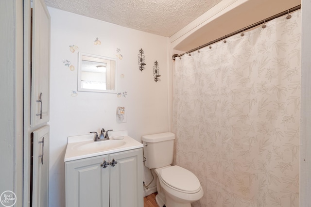 bathroom with vanity, a textured ceiling, and toilet