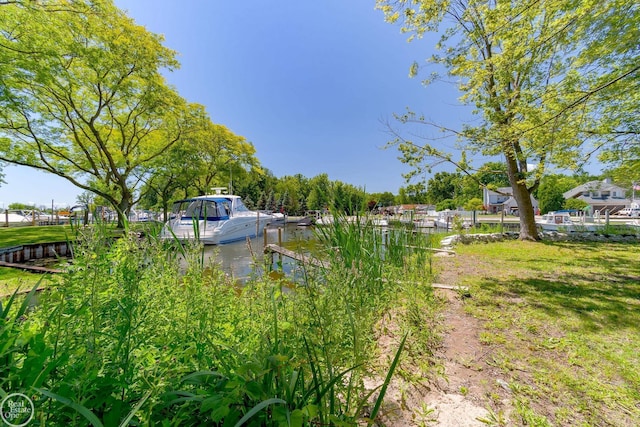 view of yard featuring a water view and a boat dock