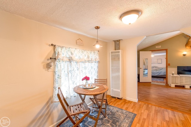 dining room featuring a textured ceiling and light wood-type flooring