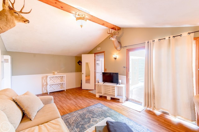 living room featuring hardwood / wood-style flooring, plenty of natural light, and lofted ceiling with beams