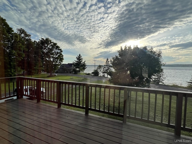 deck with a water view and a lawn