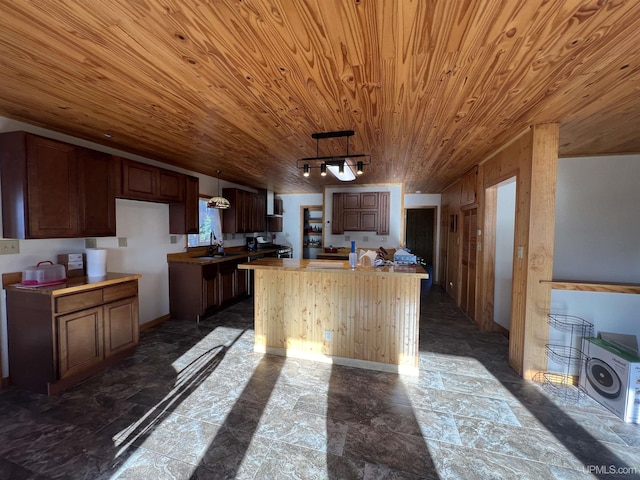 kitchen featuring decorative light fixtures, sink, a center island, track lighting, and wooden ceiling