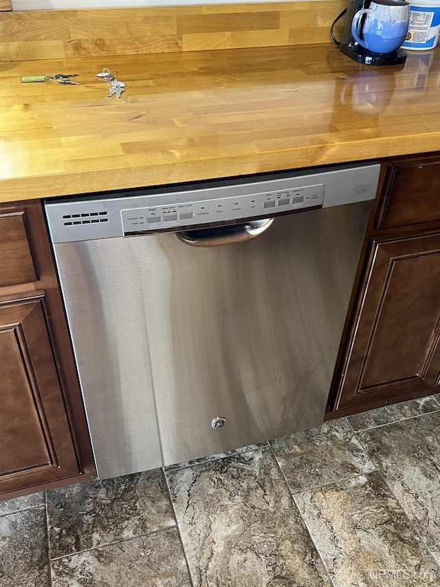 room details with wood counters, stainless steel dishwasher, and dark brown cabinetry