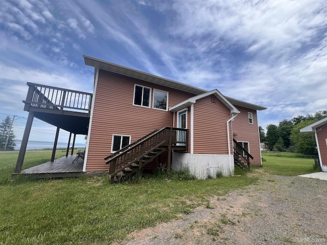 back of house with a deck and a lawn