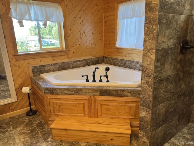 bathroom with a tub and wooden walls