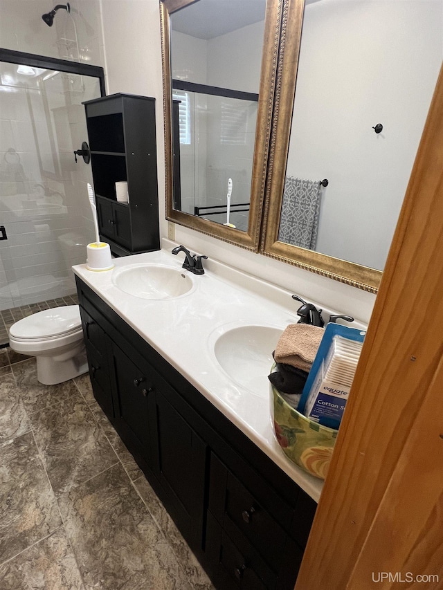 bathroom with vanity, a shower with door, and toilet