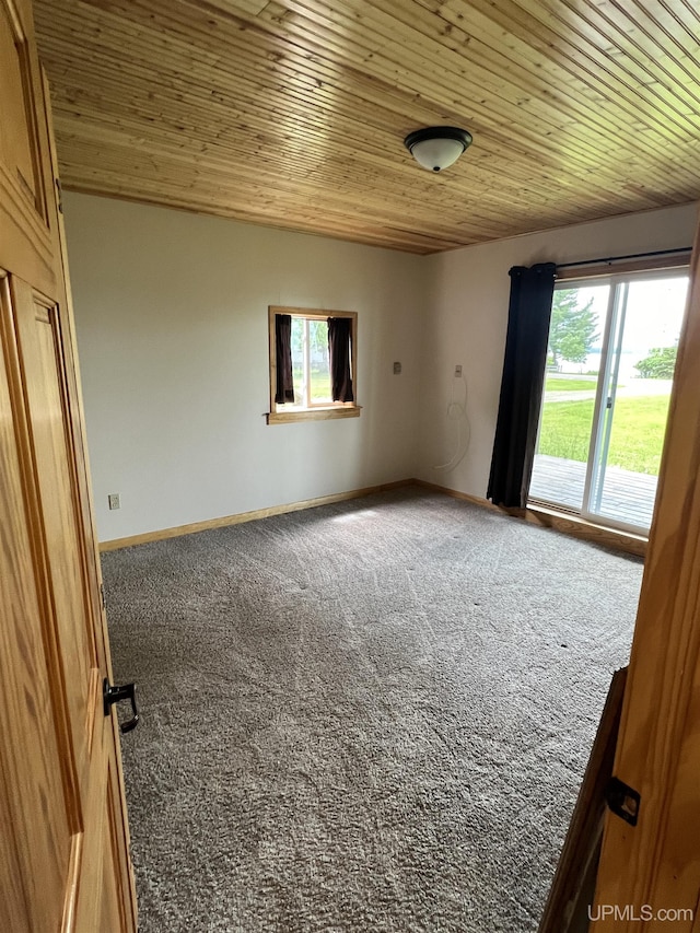 unfurnished room with wooden ceiling and carpet