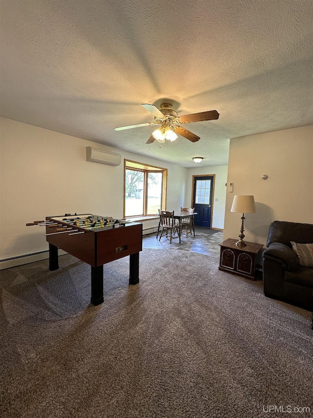 game room with carpet flooring, a wall mounted AC, a textured ceiling, and ceiling fan