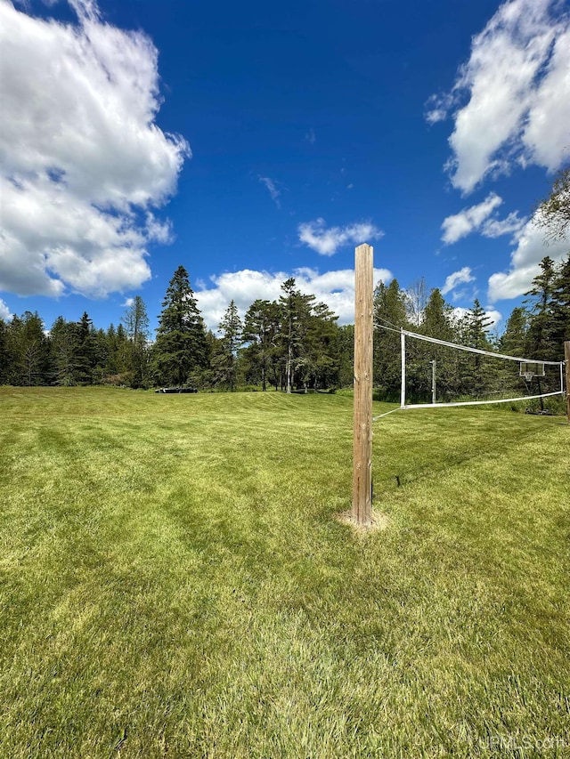 surrounding community with a lawn and volleyball court