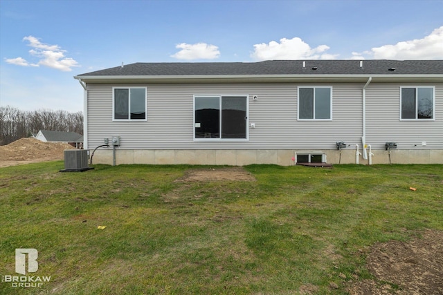 rear view of property featuring a lawn and central AC