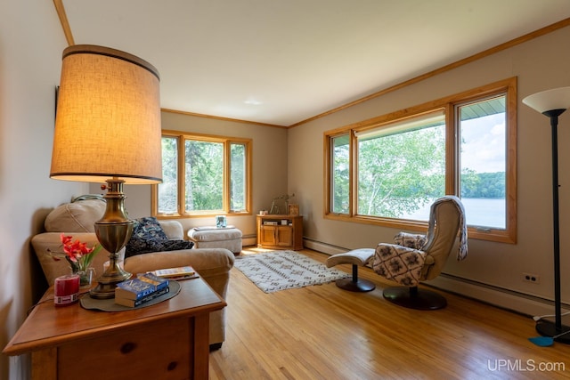 living area with a baseboard heating unit, ornamental molding, and light hardwood / wood-style flooring