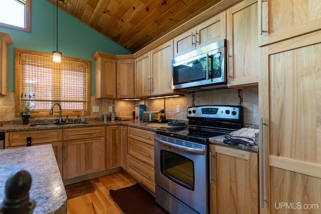 kitchen with stainless steel appliances, sink, lofted ceiling, light hardwood / wood-style floors, and hanging light fixtures