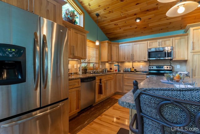 kitchen with light hardwood / wood-style floors, stainless steel appliances, sink, decorative light fixtures, and backsplash