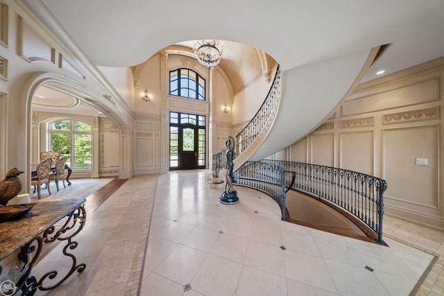 tiled foyer with a notable chandelier and high vaulted ceiling