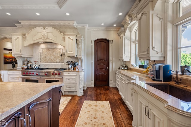 kitchen with dark wood-type flooring, double oven range, sink, and custom exhaust hood