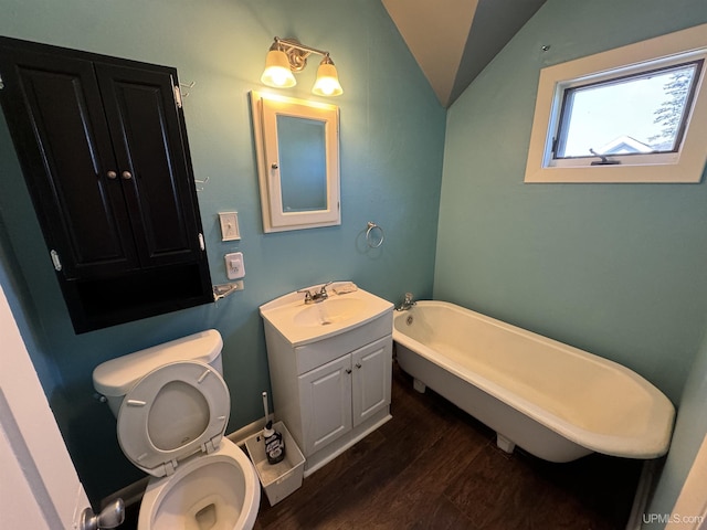 bathroom featuring vanity, hardwood / wood-style floors, lofted ceiling, toilet, and a bathing tub